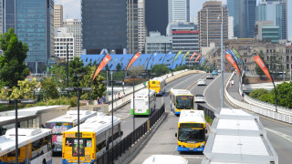 Buses driving street tall buildings - tall building free wallpaper
