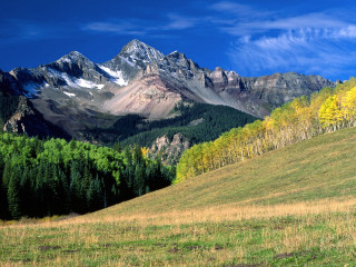 Mountain range grassy field trees - a mountain range free wallpaper