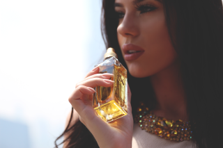 Woman holding perfume bottle serious - a bottle of perfume free wallpaper