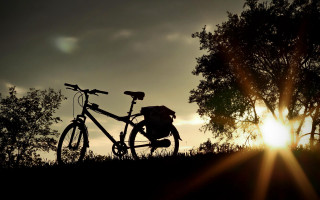 Bike parked hill sunset trees - the sun setting behind free wallpaper