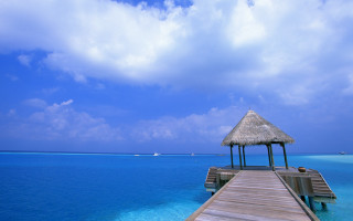 Pier thatchedroof ocean boat cloudyday - a cloudy day free wallpaper