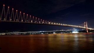 Long bridge night water lights - side and a city in the background free wallpaper
