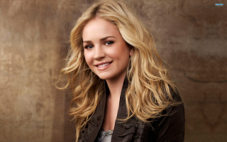 Blonde smiling woman brown background - a brown jacket free wallpaper