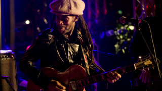 Man dreadlocks guitar dark room - free light wallpaper