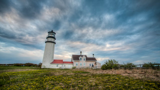 Lighthouse grassy hill cloudy sky - a field of flowers free wallpaper