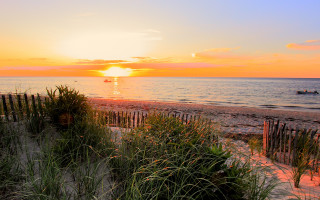 Sunset ocean beach fence boat - a sunset over the ocean free wallpaper
