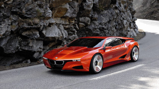 Red sports car driving rocky - a road next free wallpaper