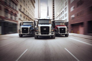 Trucks driving city street tall - a city street next free wallpaper