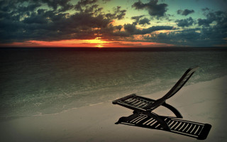 Chair sandy beach cloudy sky - a sandy beach under a cloudy sky free wallpaper