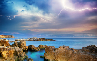 Lightning strike rocky coastline water - stormy weather free wallpaper