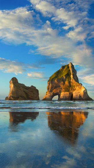 Rock formation beach sky clouds - a rock formation free wallpaper