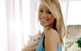 Woman holding white cat smiling - a window behind her free wallpaper