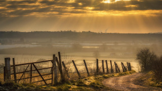 Dirt road fence field sunbeam 3 - a fence and a field in the background free wallpaper