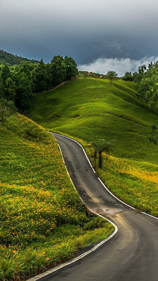 Winding road green hillside cloudy - free landscape wallpaper