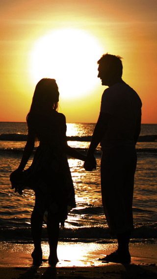 Couple holding hands beach sunset - romantic free wallpaper