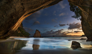 Cave entrance ocean mountains night - a view of the ocean and mountains free wallpaper