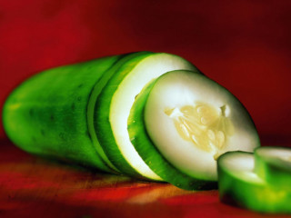 Cucumber sliced red surface background - a red cloth free wallpaper