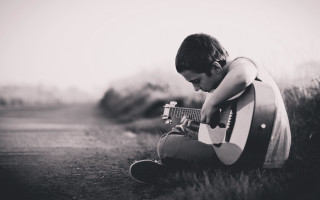 Young boy grass playing guitar - his knee free wallpaper