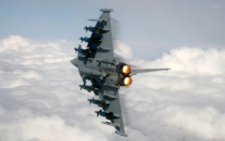 Fighter jet flying above clouds 6 - a yellow light free wallpaper