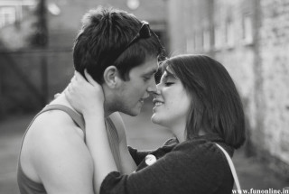 Man woman cuddling black white - a brick wall behind them free wallpaper