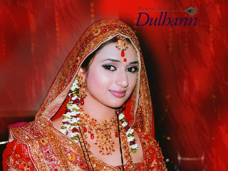 Bridal woman red gold jewelry - a red wall behind her free wallpaper