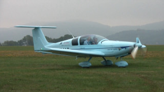 Small blue plane green field - the background in the distance free wallpaper