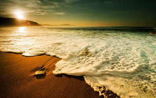 Beach waves sunset mountain sand - a mountain in the distance free wallpaper