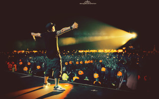 Man standing stage arms outstretched - a crowd of people free wallpaper