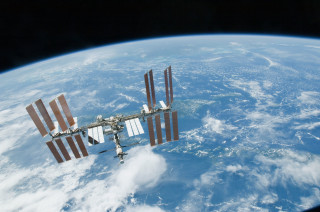 Satellite flying over earth clouds - over the earth free wallpaper