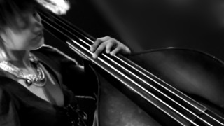 Woman holding bass serious look - her right hand free wallpaper