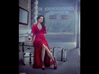 Woman red dress sitting suitcase - promotional image free wallpaper
