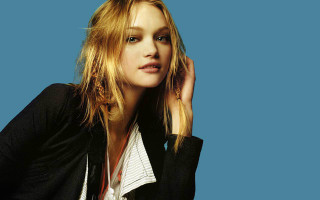 Woman blonde longhair bluebackground blackjacket - her shoulder free wallpaper