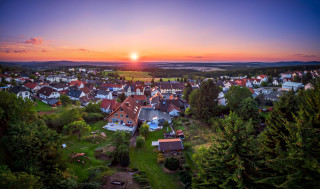 Sunset small town trees houses - a large body of water free wallpaper