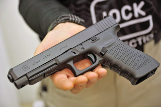 Person gun black shirt logo - a person holding free wallpaper