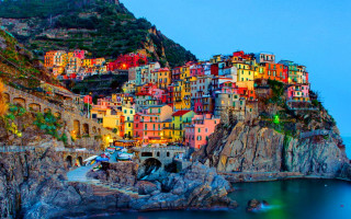 Colorful village cliff water night - the water below free wallpaper