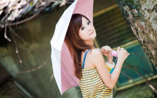 Woman holding umbrella next to - a tree in a park free wallpaper
