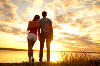 Beach sunset couple romantic ocean - the sun setting behind them free wallpaper