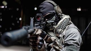 Masked man aiming gun holding - his hand and a gun free wallpaper