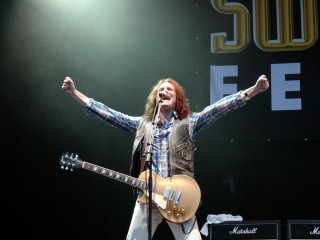 Man guitar stage arms up - his hands out in the air free wallpaper
