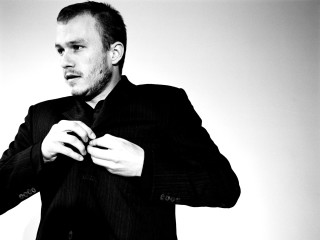 Man suit adjusting tie blackwhite - a white wall free wallpaper
