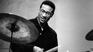 Man playing drums room microphone - front of him free wallpaper