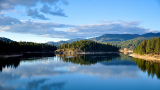 Lake trees mountains cloudy sky 8 - tree and mountains under a cloudy sky free wallpaper