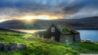 House grass roof hill lake - a sunset in the background free wallpaper