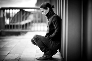 Man sitting wall down hands - daryush shokof free wallpaper