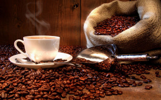 Coffee cup on beans sack 2 - top of a pile free wallpaper