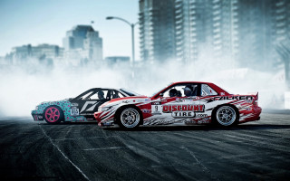 Cars racing track city dust - a city skyline in the background free wallpaper