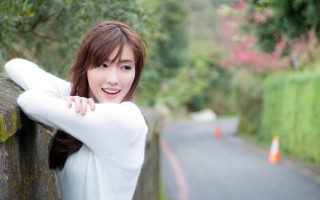 Woman leaning wall smile blue - a wall free wallpaper