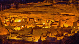 Cave lit buildings rocks nighttime - primitivism free wallpaper