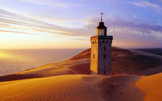 Tower desert sunset water distance - a sunset in the background and a body of water free wallpaper