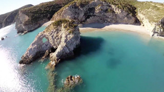 Beach rock formation water aerial - a rock formation in the middle of it free wallpaper